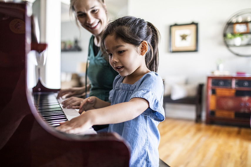 Child Playing Piano With Instructor